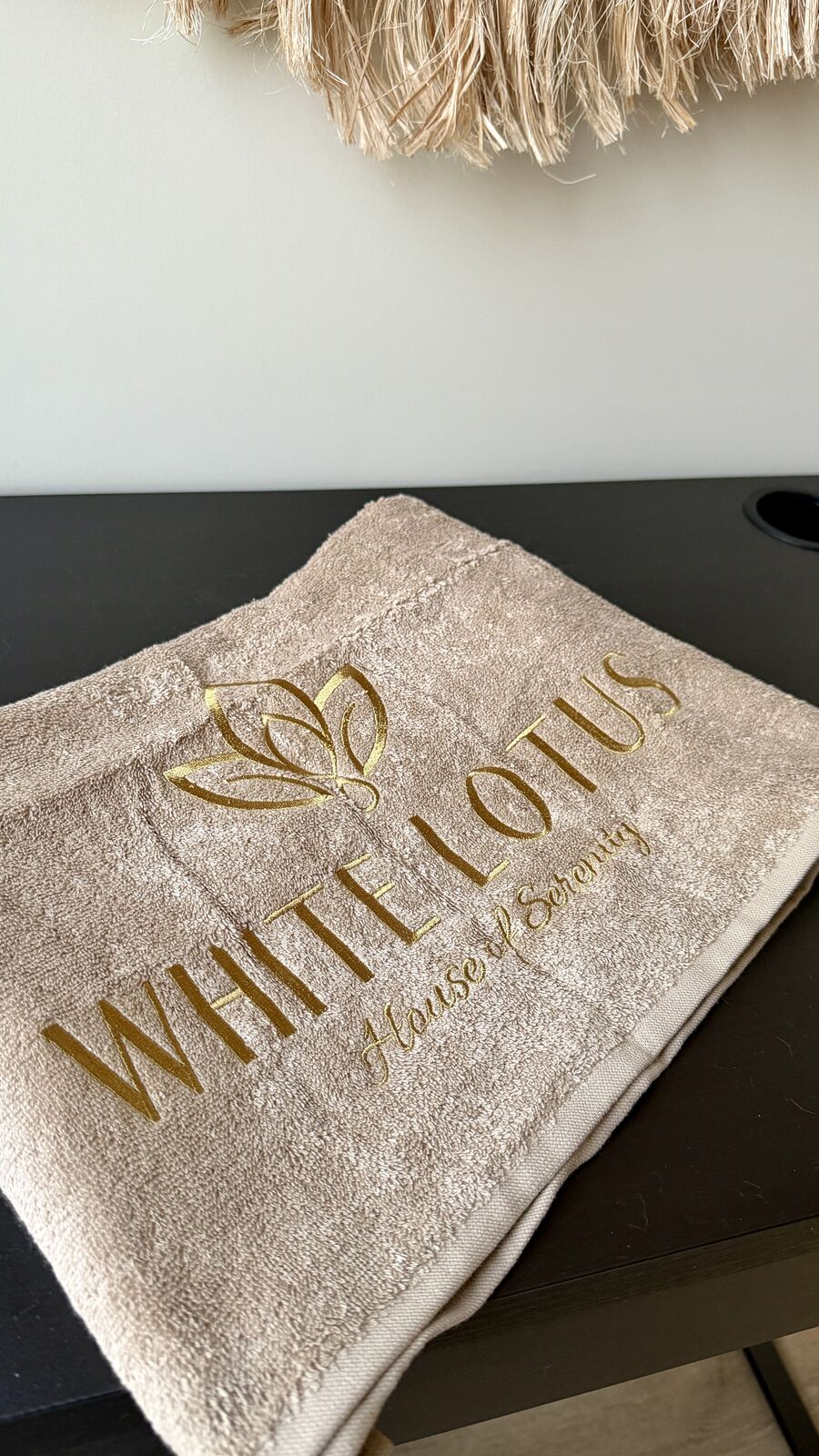 Embroidered White Lotus towel at the spa in Grimbergen